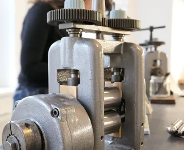 Metal rolling mill machine on table.