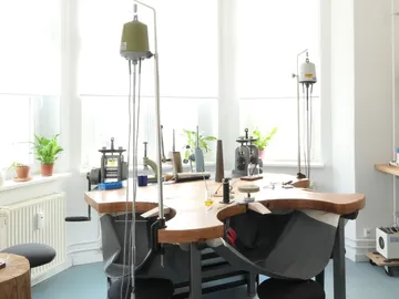 Schmuckwerkstatt mit Werkzeugen und Bänken.