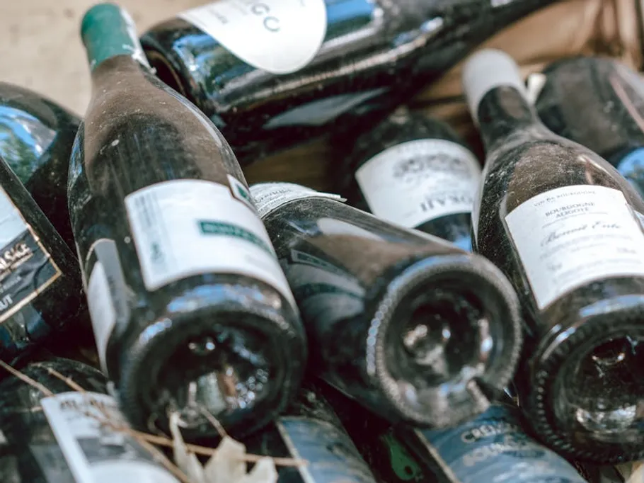 Many wine bottles are left unsorted in the frame.
