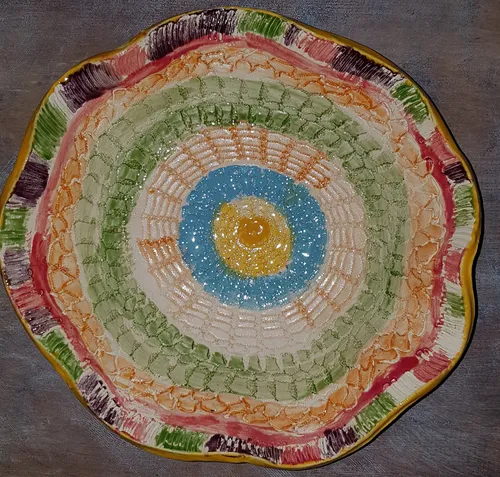 Colorful ceramic plate with concentric patterns on table.