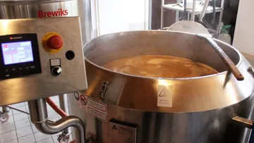 Stainless steel brewing vat in use.