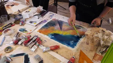 Leute, die lebendige abstrakte Kunstwerke auf den Tisch malen.