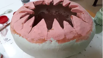 Clay sculpture with jagged top edge.