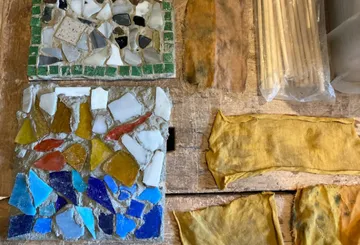 Colorful tiles and cloths on a wooden table.