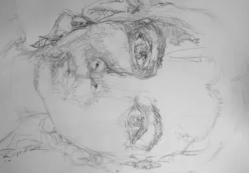 Detailed pencil sketch of a face on paper.