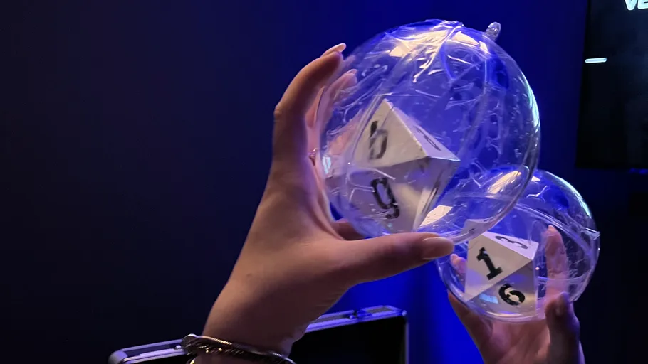 Hands holding transparent spheres with dice inside.