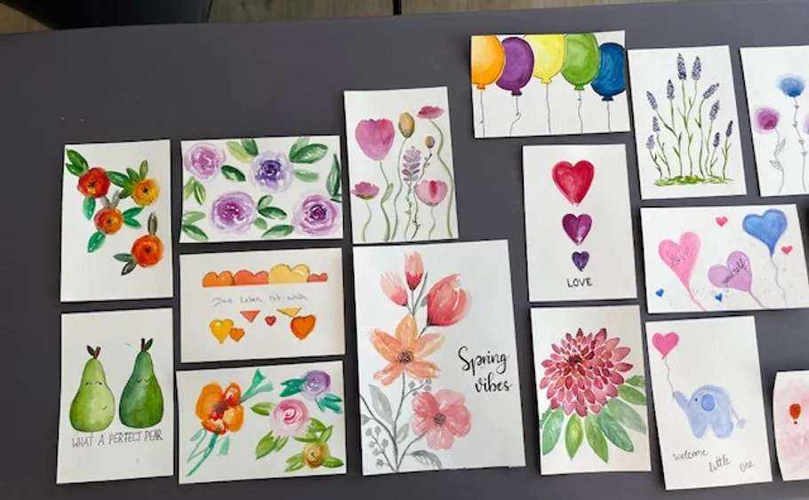 Bunte handbemalte Karten mit Blumenmustern.