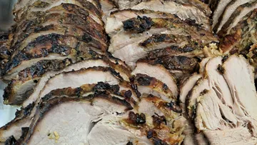 Scheiben von gewürztem Schweinebraten, dicht angeordnet.
