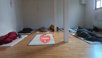 People lying on mats in a room.