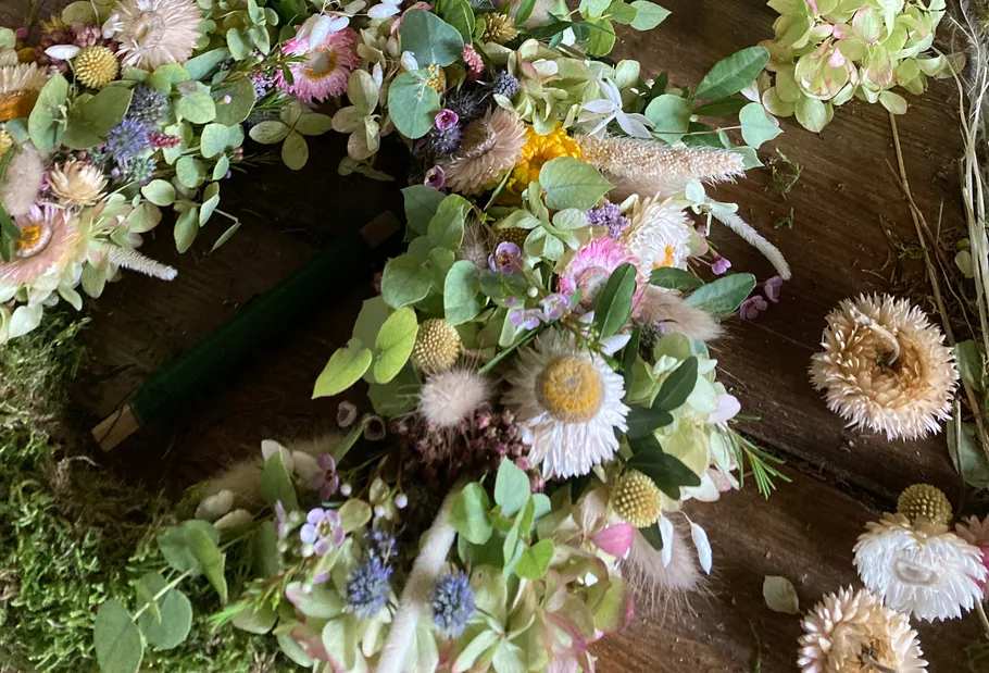 Floral wreath with assorted flowers on table.