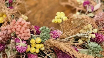 Colorful dried floral wreath on tabletop.