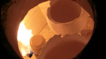 Innenausstattung des Ofens mit Keramikteilen und Flamme.