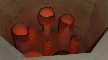 Keramiktöpfe, die in einem Ofen glühen.