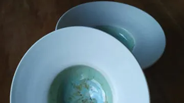 Zwei Keramikschalen mit grünem Innenraum, überlappend.