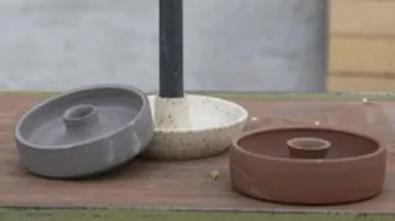 Three round patio umbrella bases on table.