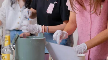 People crafting with gloves and materials on table.
