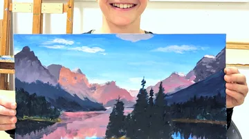 Person, die ein Landschaftsgemälde von Bergen und Seen in der Hand hält.