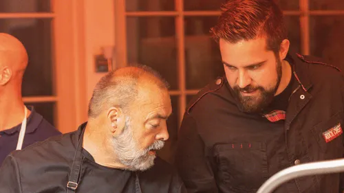 Two chefs discussing while cooking together.