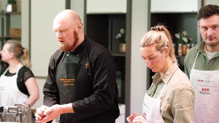 Chefs in kitchen preparing food together.
