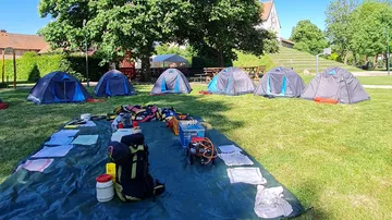 Zelte und Campingausrüstung sind im Freien angeordnet.