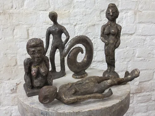 Five figures stand on a round wooden tray.