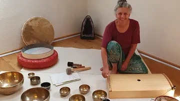 Frau mit Musikinstrumenten im Zimmer.