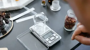 Digital scale with beaker on table.