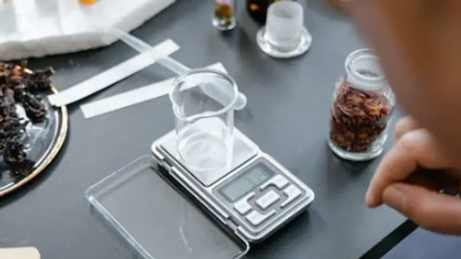 Digitale Waage mit Becher auf dem Tisch.