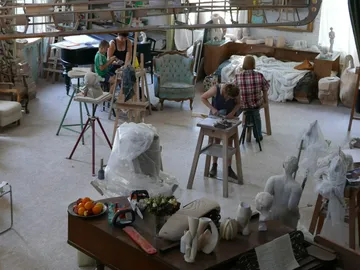 Sculpture workshop with people sitting at work.