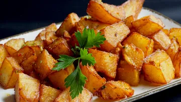 Crispy roasted potatoes with parsley garnish.