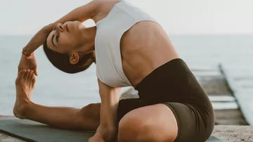 Person, die Yoga am Meer praktiziert.