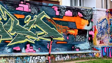 Colorful graffiti on urban wall, scooter in front.