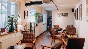 Cozy lounge with armchairs and potted plants.