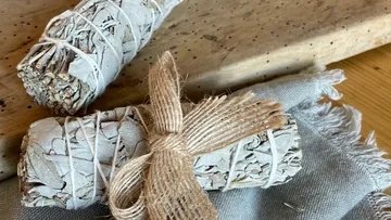 Salbeibündel auf Holzoberfläche mit Stoff.