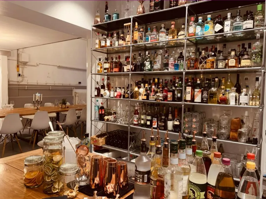 Shelf with spirits and glasses in a modern bar setting.