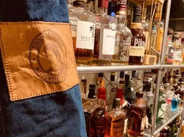 Leather patch with shelves of liquor bottles.
