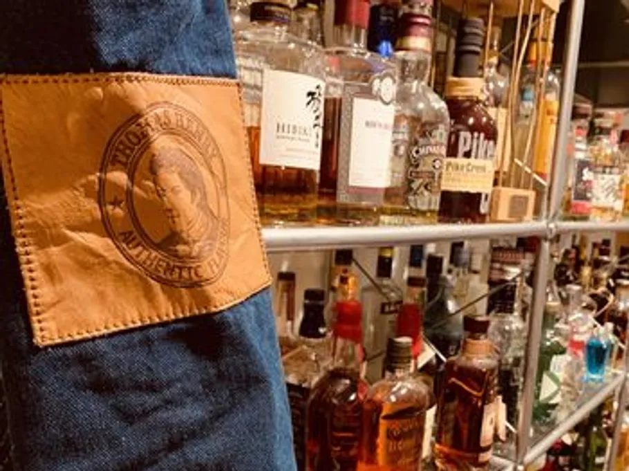 Leather patch with shelves of liquor bottles.