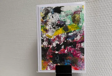 Abstract paint splash art on white card.