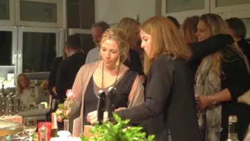 Gruppe von Menschen, die drinnen auf einer Party Kontakte knüpfen.