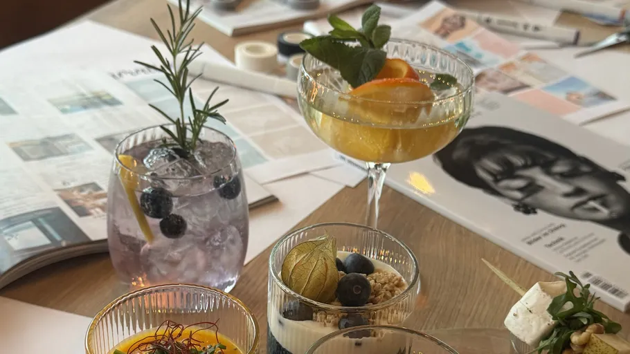 Assorted cocktails and desserts on a table with magazines.
