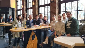 Eine Gruppe von Menschen versammelte sich drinnen an Kneipentischen.