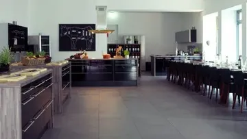 Moderne Küche mit Kochinsel und Esstisch.
