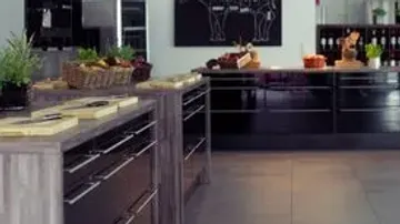 Modern kitchen with herbs and baskets on counters.