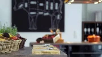 Küche mit Obstkörben, Schneidebrettern und Kuhdiagramm.