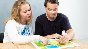 Two people examining a map on a table.