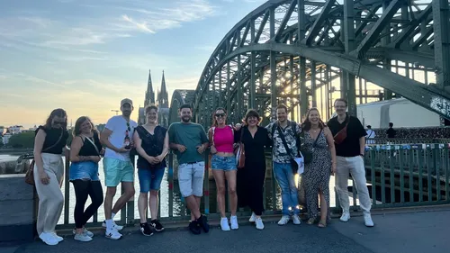 Group posing on bridge near cathedral.