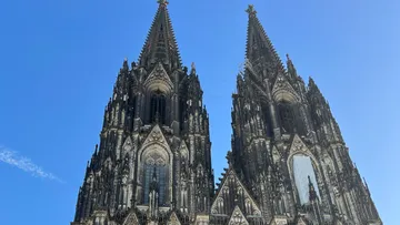 Gotische Kathedralentürme vor strahlend blauem Himmel.