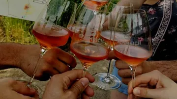 Leute, die draußen Gläser mit Roséwein klirren.