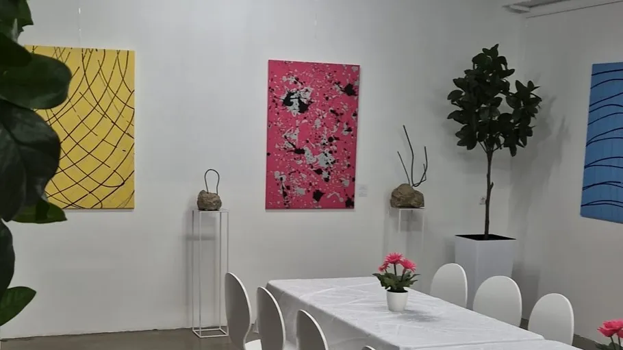 Modern art gallery with colorful paintings and plants.