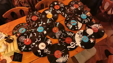 Vinyl record clocks with unique designs on table.